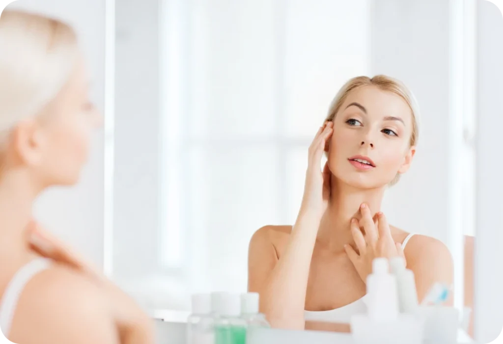 femme observant peau mirroir Comment améliorer la qualité de sa peau ? PRISME – Maison de soins esthétiques